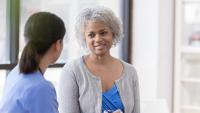 Middle-aged woman speaks with her care provider.